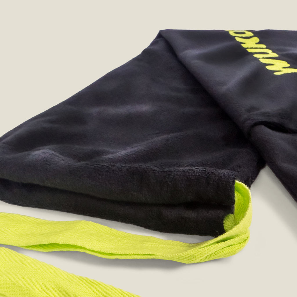 Macro image of WUKA hot water bottle’s ultra-soft fleece cover with neon green strap detailing